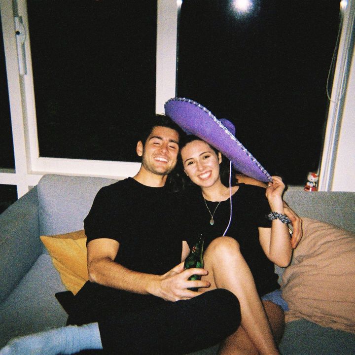 Hayden and Phoebe on a couch, Phoebe under a purple sombrero