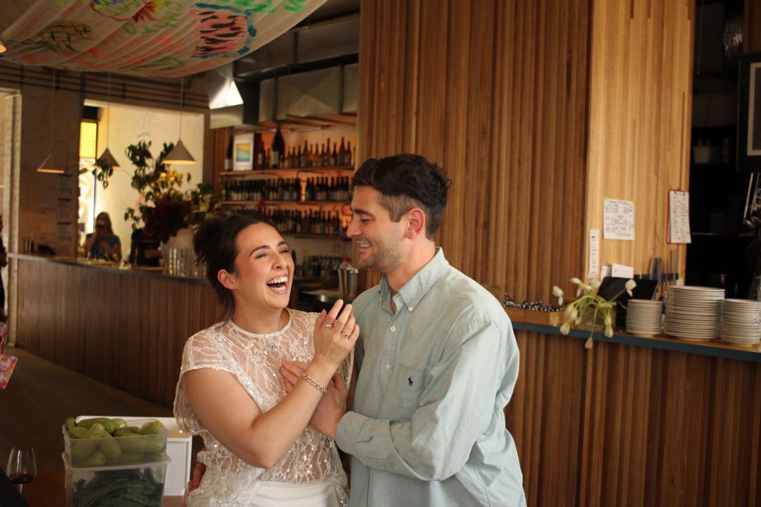 Phoebe and Hayden laughing together at a wine bar