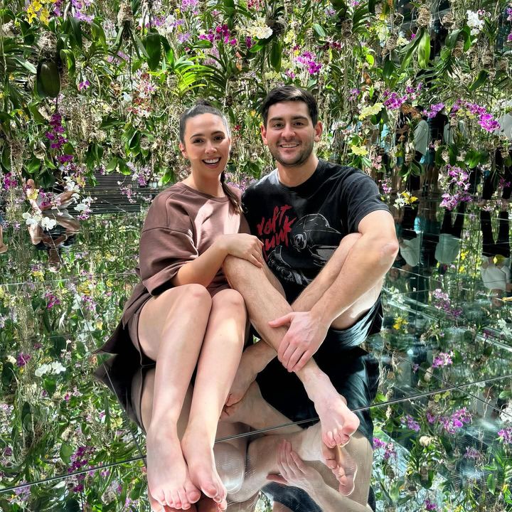 Hayden and Phoebe sitting in a mirrored room of hanging orchids